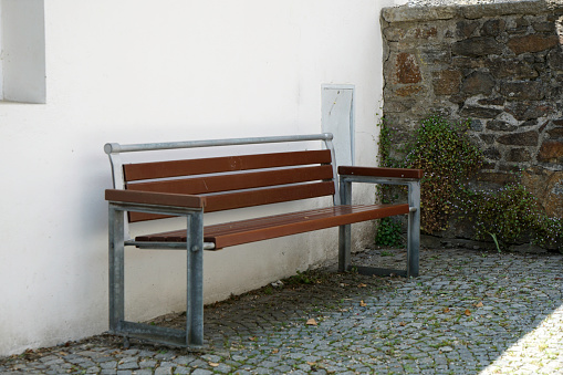 Two empty bench in front of wall.