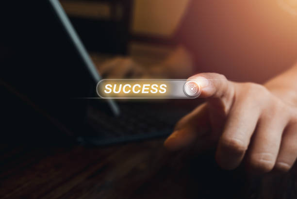 istock Word SUCCESS on virtual screen with 3d button or tab switch with target icon, pressing by person who working with laptop computer, dark background. Business success in career or education concepts. 1967128390