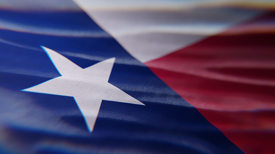 The Texas state flag fluttering in the wind, dramatic lighting