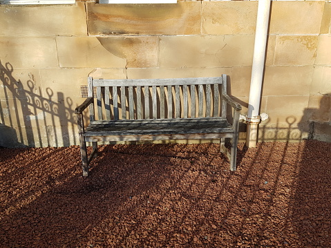 Wooden garden bench in a sunny weather, Glasgow Scotland England UK