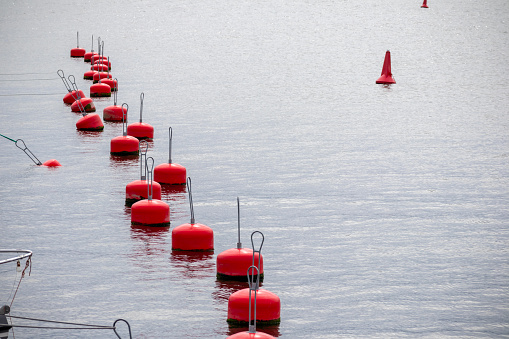A row of red buoys on the water
