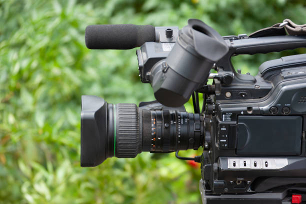 istock Camcorder, TV gathering style ENG camera, outdoors, green grass background 1967187585