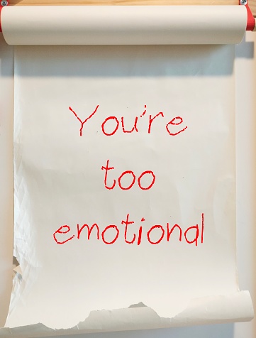 Paper roll with handwriting YOU ARE TOO EMOTIONAL - gaslighting way to accuse or emotional abuse others to question their beliefs or doubt their perception and become distressed