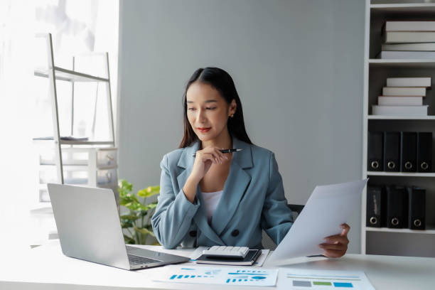 istock Young happy businesswoman using computer in office, Stylish Beautiful Manager Smiling, Working on Financial and Marketing Projects, Portrait of a young businesswoman working on a laptop in an office 1967203441