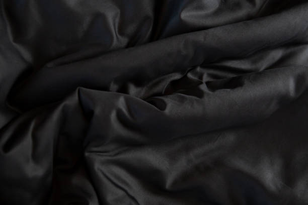 istock Texture of black crumpled bed linen with waves 1967267379