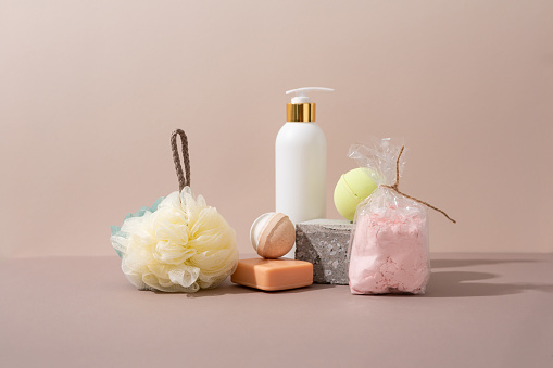 white cosmetic jar bath foam  and washcloth, soap on beige surface