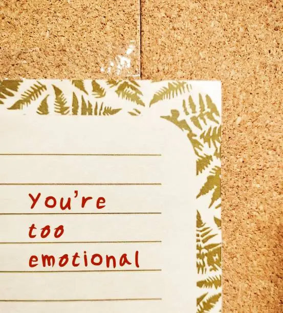 Letter with handwriting YOU ARE TOO EMOTIONAL - gaslighting way to accuse or emotional abuse others to question their beliefs or doubt their perception and become distressed