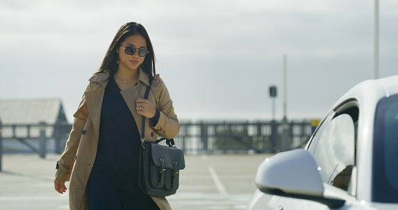 Businesswoman, walking and car for travel to work, transport and calm for journey to workplace in city. Young person, job and trendy corporate fashion to commute and transportation for entrepreneur