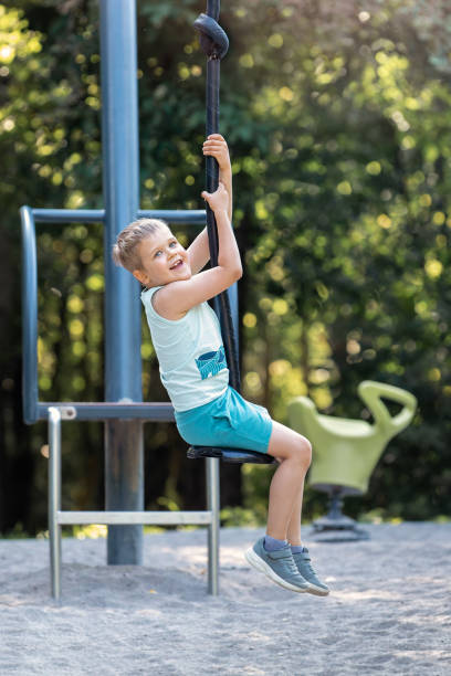 istock A smiling child rides a single rope swing. 1967344261
