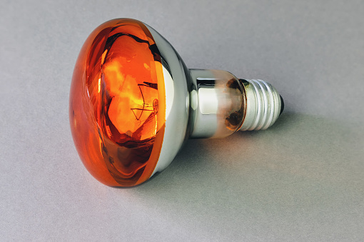 Electric lamp with orange on a gray background, for light effects