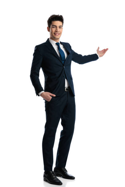 istock proud elegant man smiling, presenting to side while holding one hand in pocket 1967370438