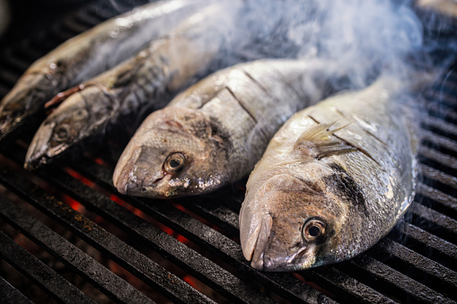 Raw fish roasting on a grill