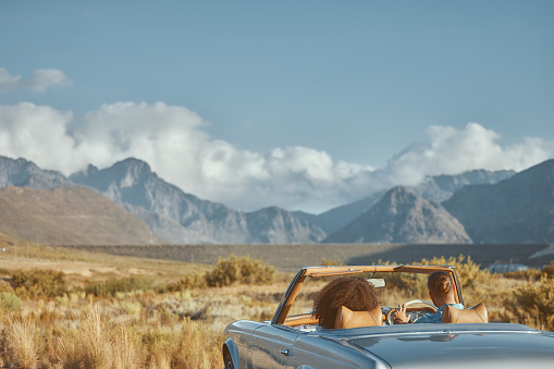 Relax, back view or couple in car on road trip on holiday together with love, care and adventure. Romantic, interracial or people in countryside or transport for vacation for mountains or honeymoon