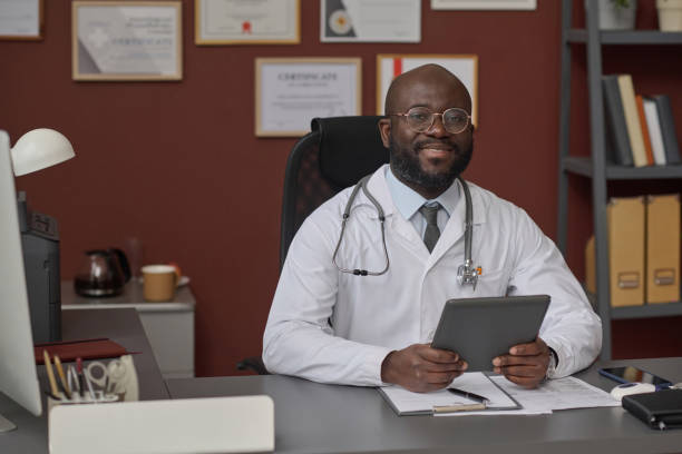 istock African American Physician Posing at His Desk During Workday in Office 1967449503