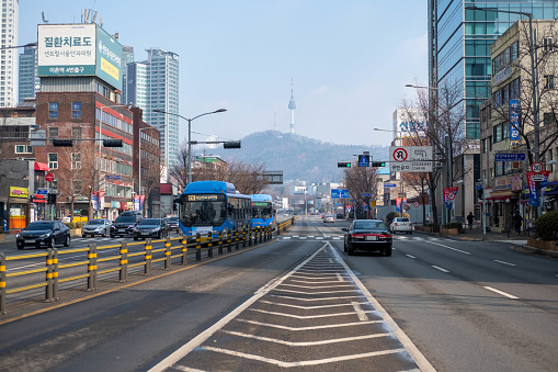 Seoul, South Korea - February 19, 2023: Winter view of N Seoul Tower, cars, buses, and buildings along the road in the Yongsan-gu area.