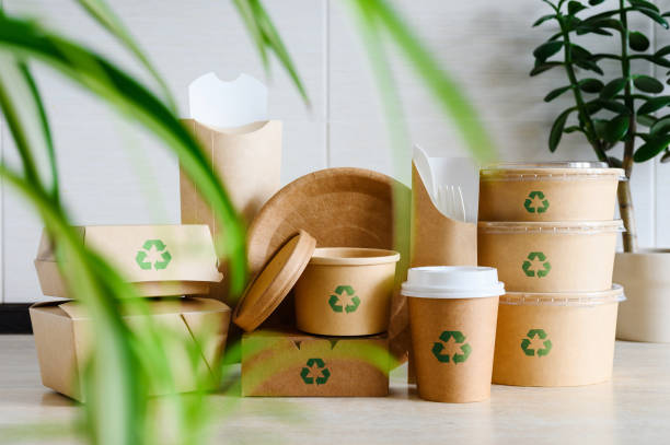 istock Eco-friendly disposable green leaf tableware. Paper packaging with a recycling sign. Recycling and environmental protection concept. 1967507069