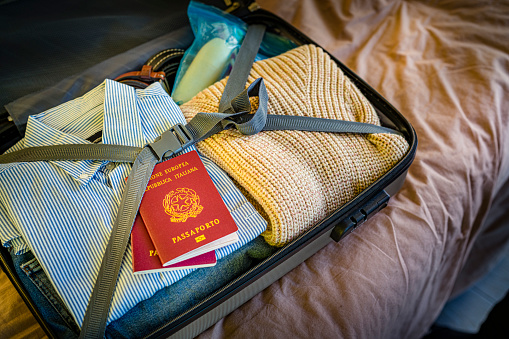 Italian passports and suitcase ready for a trip. High resolution 42Mp indoors digital capture taken with Sony A7rII and Sony FE 90mm f2.8 macro G OSS lens