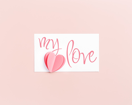 Pink cute cut heart and paper card with text my love, love note on pink background. Minimal trend flat lay, pastel color, mock up valentine Day card or wedding invitation. Romantic holiday concept