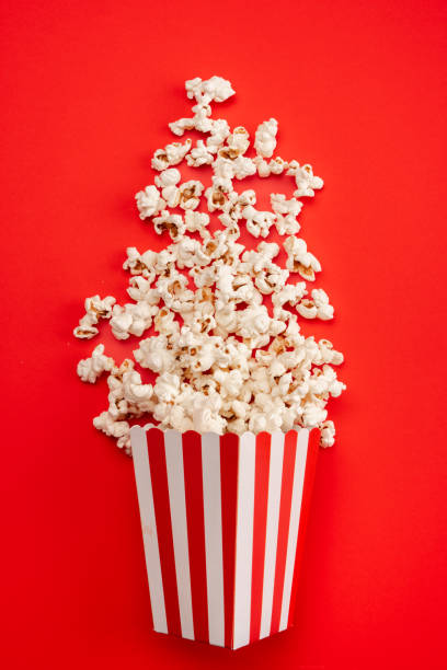 istock Popcorn in red and white striped paper box isolated on red  background 1967534167