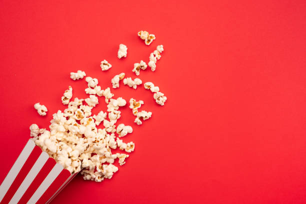 popcorn in red and white striped paper box isolated on red  background - large cheese beautiful red ストックフォトと画像