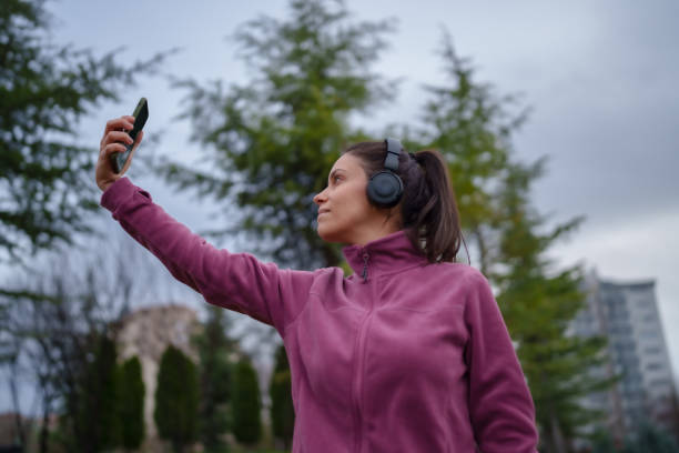 istock Young woman using mobile phone, exercise in public park, outdoors at night. 1967535061