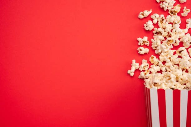 istock Popcorn in red and white striped paper box isolated on red  background 1967535320