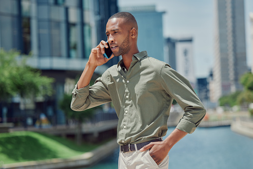 Businessman, phone call and city for conversation, communication or proposal in travel or sightseeing. Man or salesman talking on mobile smartphone for business discussion by river in Los Angeles
