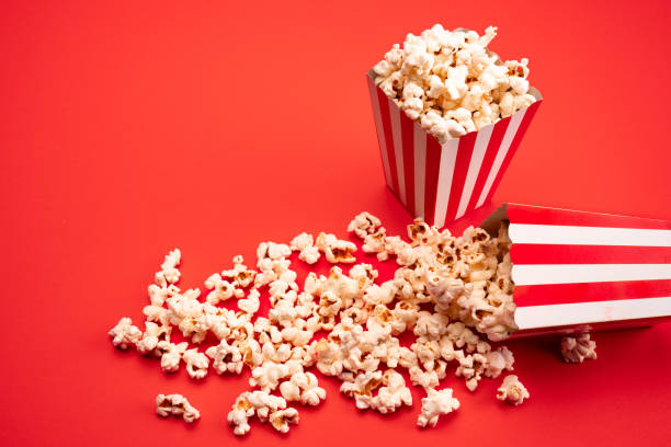 istock Popcorn in red and white striped paper box isolated on red  background 1967536247