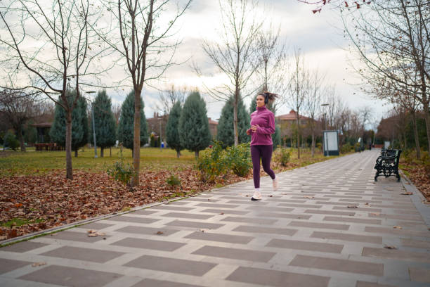 istock Young woman jogging in public park, outdoors at night. 1967542605