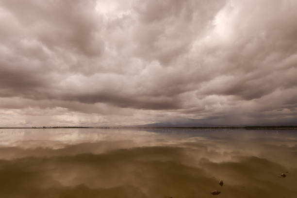 dramatic sky reflect in the smooth water surface of a lake in Amboseli NP