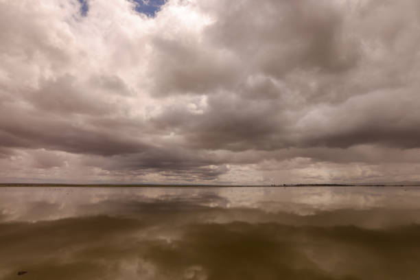 dramatic sky reflect in the smooth water surface of a lake in Amboseli NP