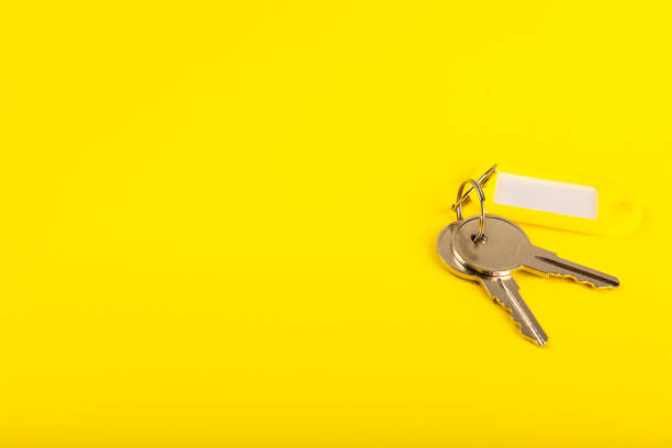 istock Keychain with key ring isolated on a colored background. Concepts for real estate and moving home or renting property. Buying a property. Mock-up keychain.Copy space. 1967557255