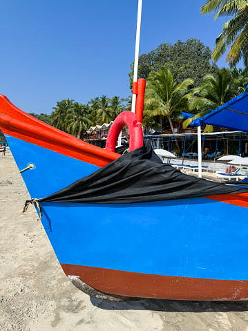 Stock photo showing close-up view of prow of wooden pleasure cruise boat moored on sand of Palolem Beach, Goa, India.