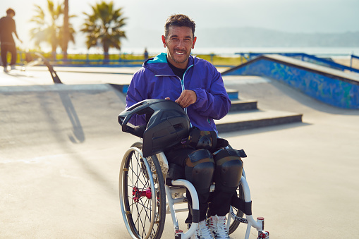 portrait smiling athlete man with disability in wheelchair at skatepark