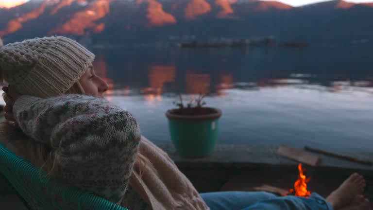 Woman enjoys outdoor fire at her home rental, stunning lake and mountain view