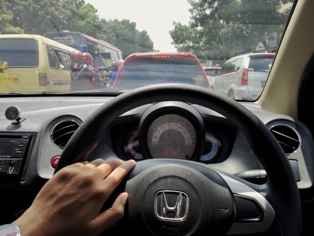 Bandung, Indonesia - January 28, 2024 : A man driving car in a traffic jam in Bandung, Indonesia