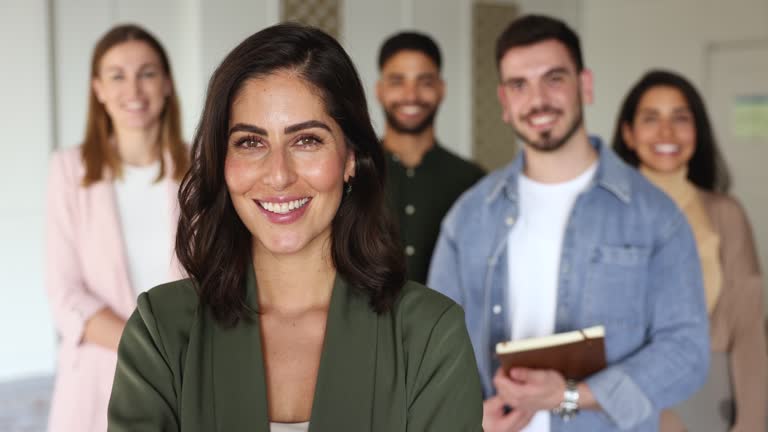 Mexican professional businesswoman, company boss and staff looking at camera