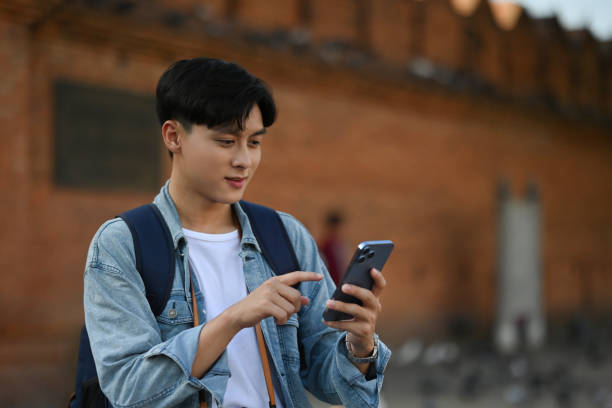 istock A backpacked male tourist using his mobile phone Tha Phae gate, at Chiangmai on background with copy space 1967663161