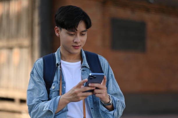istock A backpacked male traveller using his mobile phone Tha Phae gate, at Chiangmai on background with copy space 1967686460