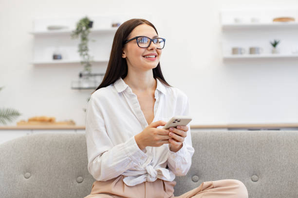 istock Woman enjoying exchanging of sms messages while sitting on cozy couch. 1967712802