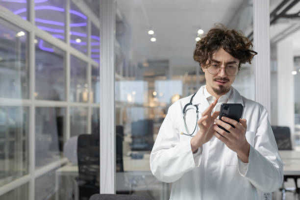 istock Doctor in White Lab Coat Using Cell Phone 1967716736