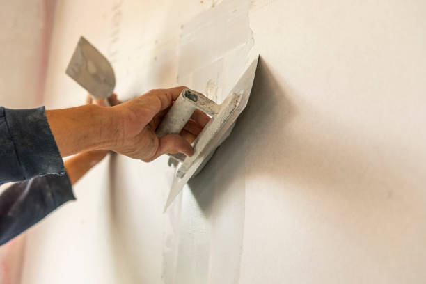 istock Old manual worker with wall plastering tools renovating house. 1967721744
