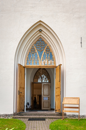 Gothic church entrance close up. Open door to church. Smiltene Lutheran Church in sunny summer day, Latvia.