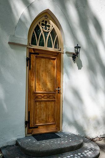 Gothic church entrance close up. Closed wooden door. Smiltene Lutheran Church in sunny summer day, Latvia.