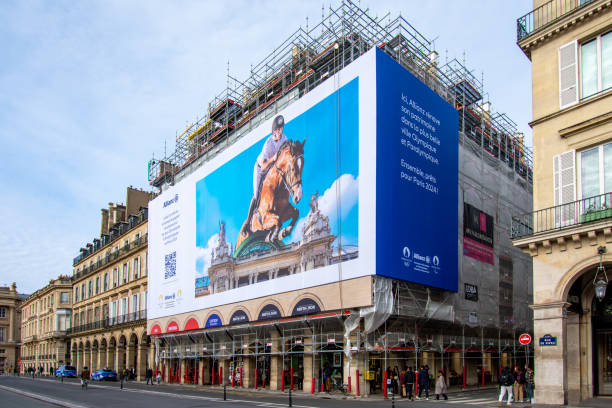 Giant advertising billboard sponsored by Allianz about the Paris 2024 Olympic games (show jumping), Paris, France Paris, France - January 27, 2024: Giant advertising billboard sponsored by Allianz about the Paris 2024 Olympic games (show jumping) on the scaffoldings of the restoration work of a parisian building olympic city stock pictures, royalty-free photos & images