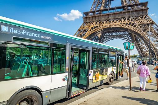 Paris, France - September 09, 2023 : RATP bus parked in front of the Eiffel Tower on a sunny day in Paris, France