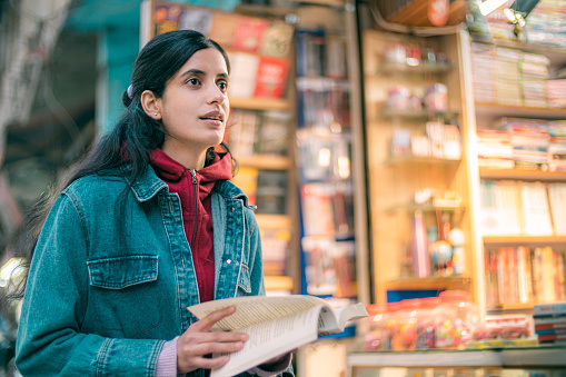 A happy, beautiful woman shops at a bookstore in the 15-minute city of Himachal Pradesh.