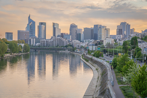 Levallois, France - 04 16 2020: Panoramic view of the Seine river and La Defense towers district from Levallois Bridge at sunrise