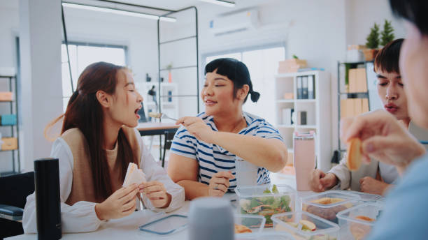 istock Office Diversity: Colleagues Enjoying Lunch break Snacks for Enhanced Bonding 1967866424