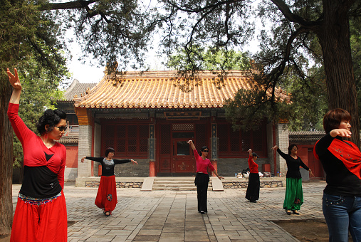 China, Beijing, June 5, 2011. A group mothers doing Tai Chi exercises for body health in the courtyard of Summer Palace complex.